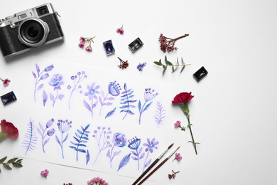 Flat lay composition with floral picture and watercolor paints on white background