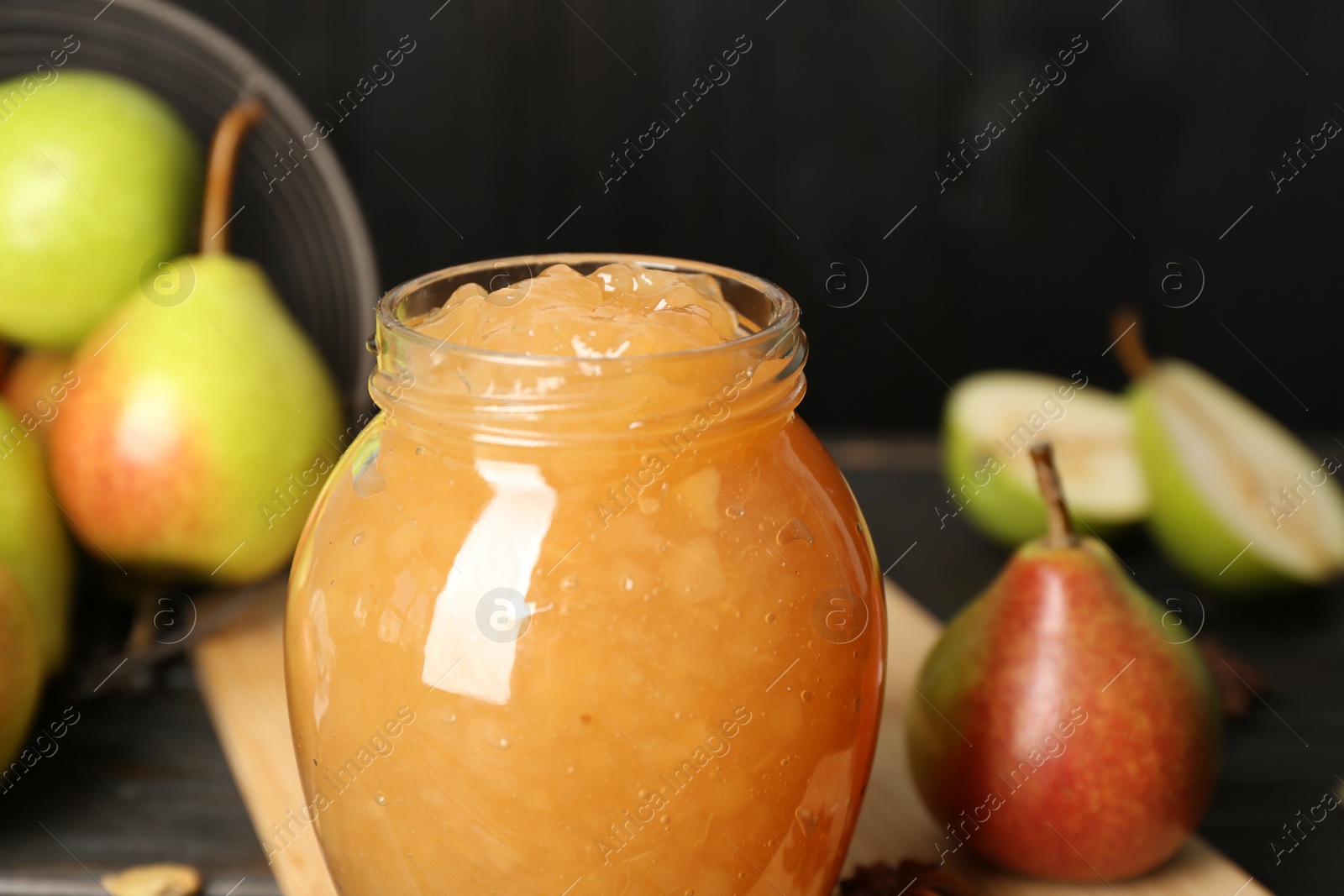 Photo of Delicious pear jam in glass jar on table, closeup