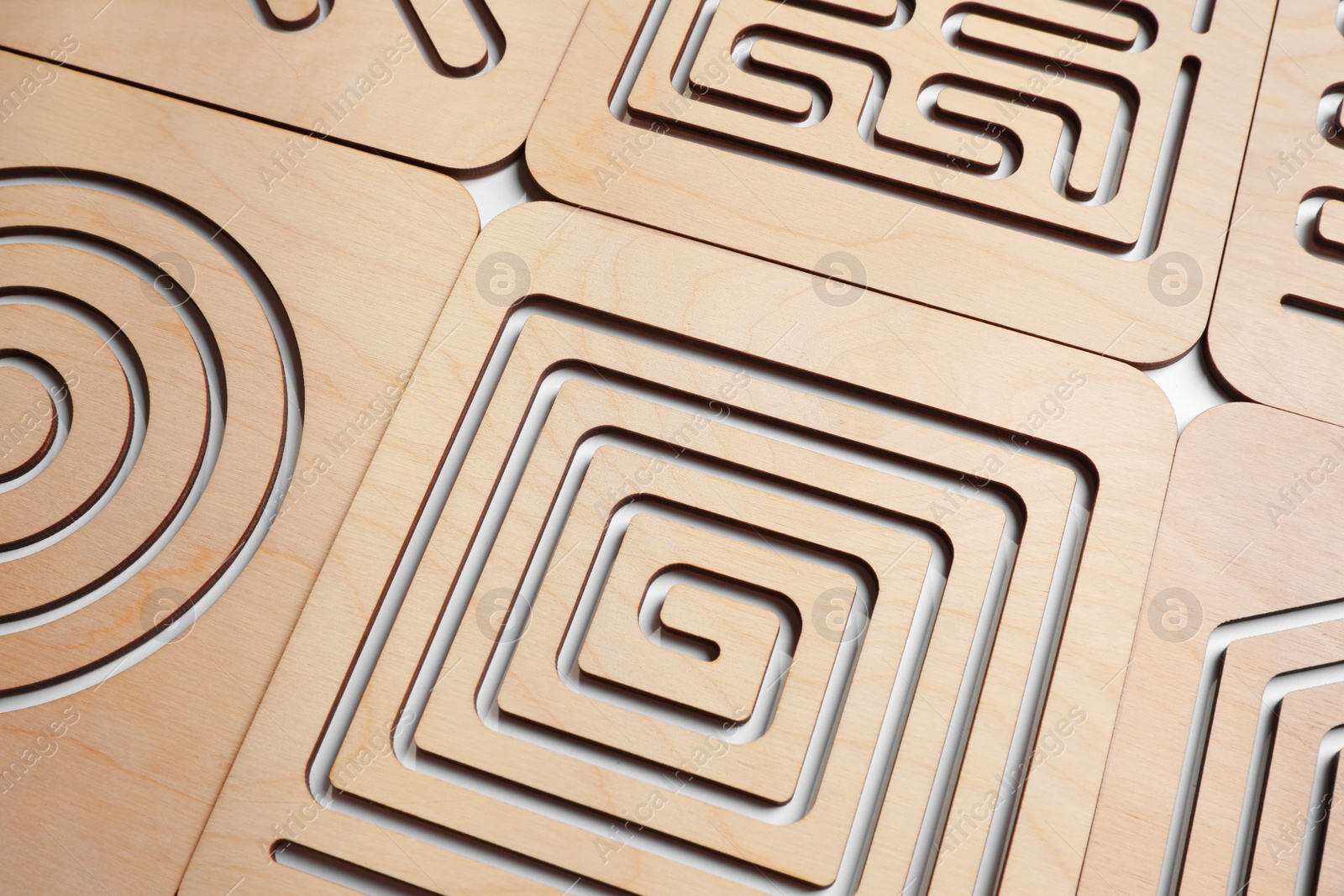 Photo of Wooden finger labyrinths on white background, closeup. Montessori toy