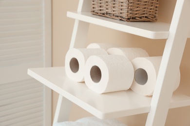 Photo of Toilet paper rolls on shelving unit in bathroom