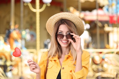 Beautiful woman with candy having fun at amusement park