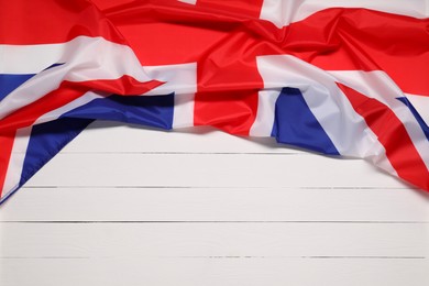 Photo of Flag of United Kingdom on white wooden background, top view. Space for text