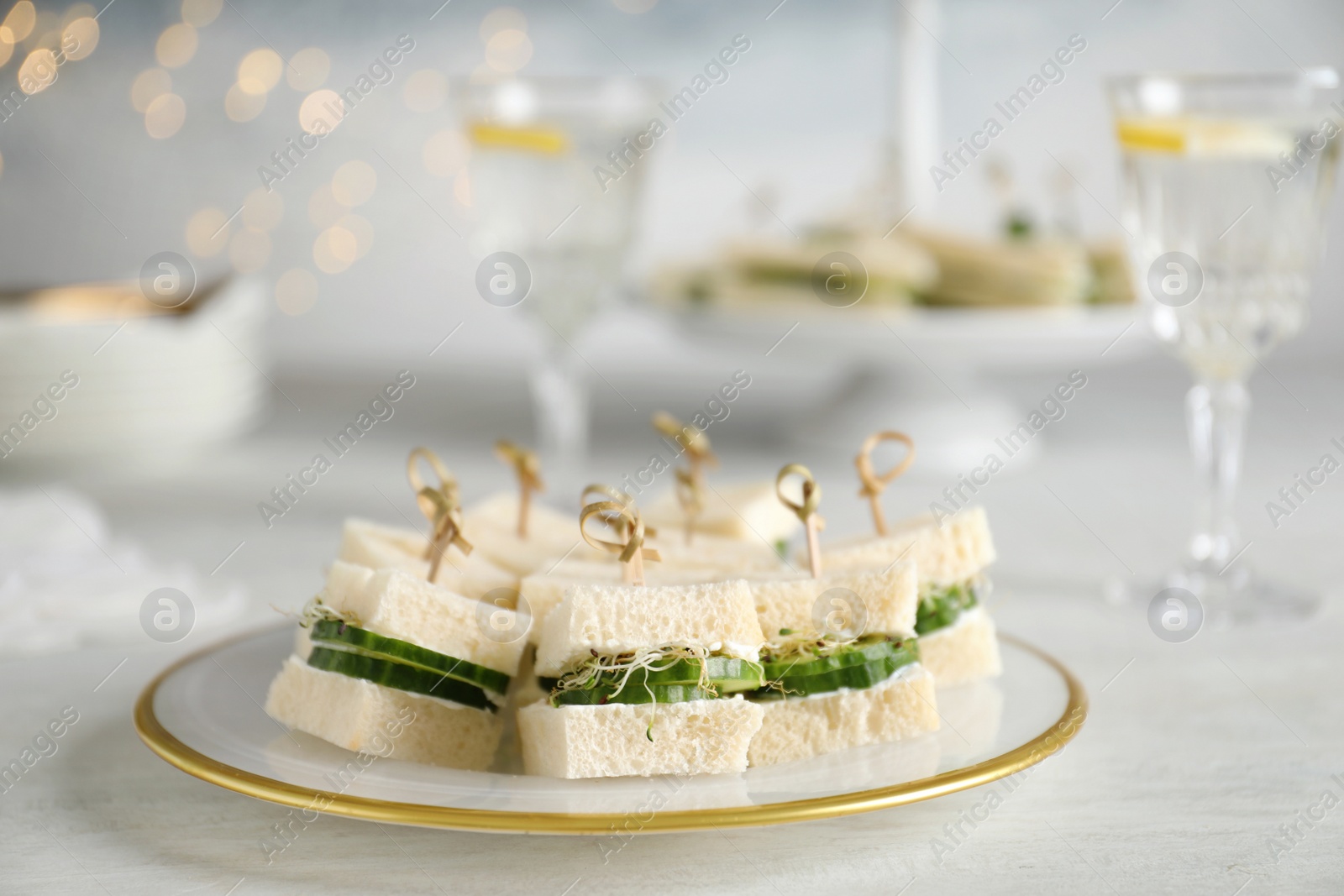 Photo of Plate with traditional English cucumber sandwiches on table. Space for text