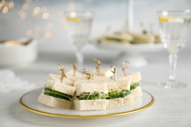 Photo of Plate with traditional English cucumber sandwiches on table. Space for text