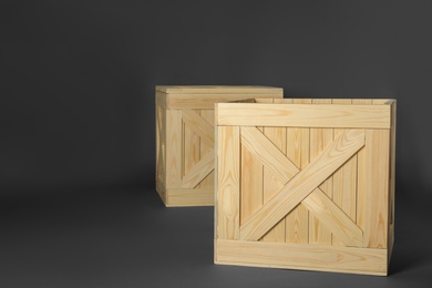 Photo of Wooden crates on dark background, space for text. Shipping containers