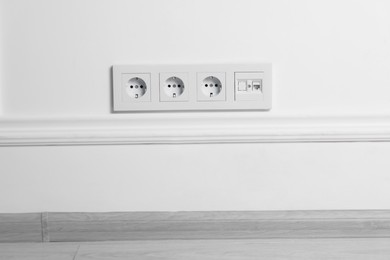 Photo of Electric power sockets on white wall indoors