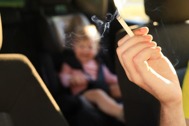 Photo of Mother with cigarette and child in car, closeup. Don't smoke near kids