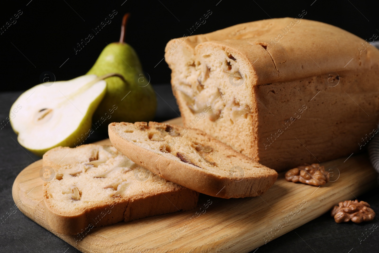 Photo of Tasty cut pear bread on black table, closeup. Homemade cake