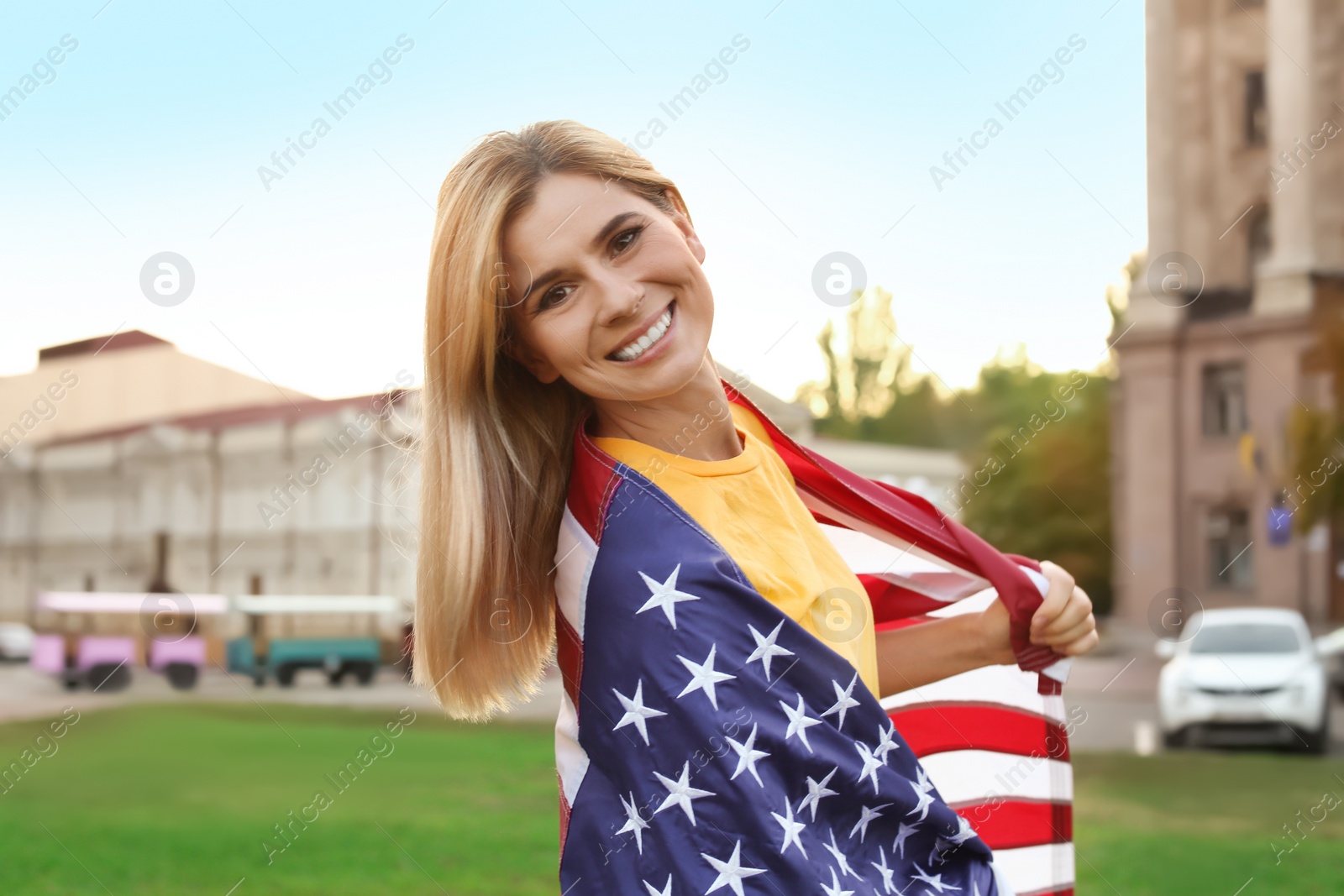 Photo of Woman with American flag on city street