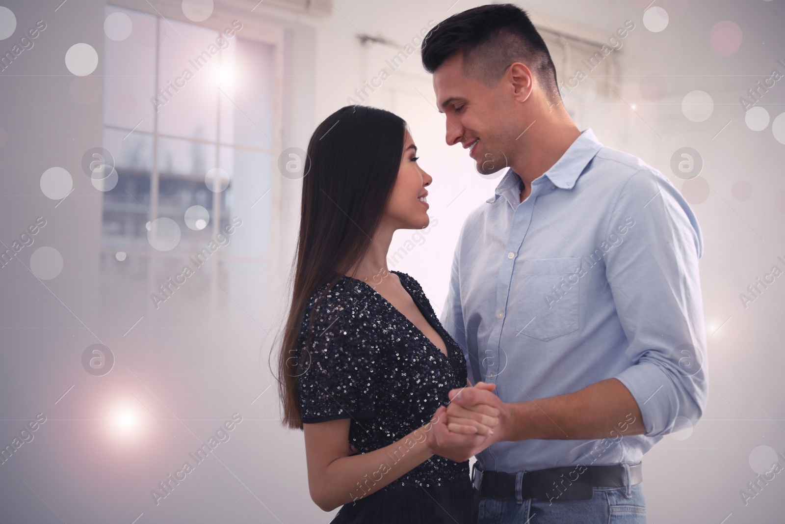 Photo of Lovely young couple dancing together in ballroom