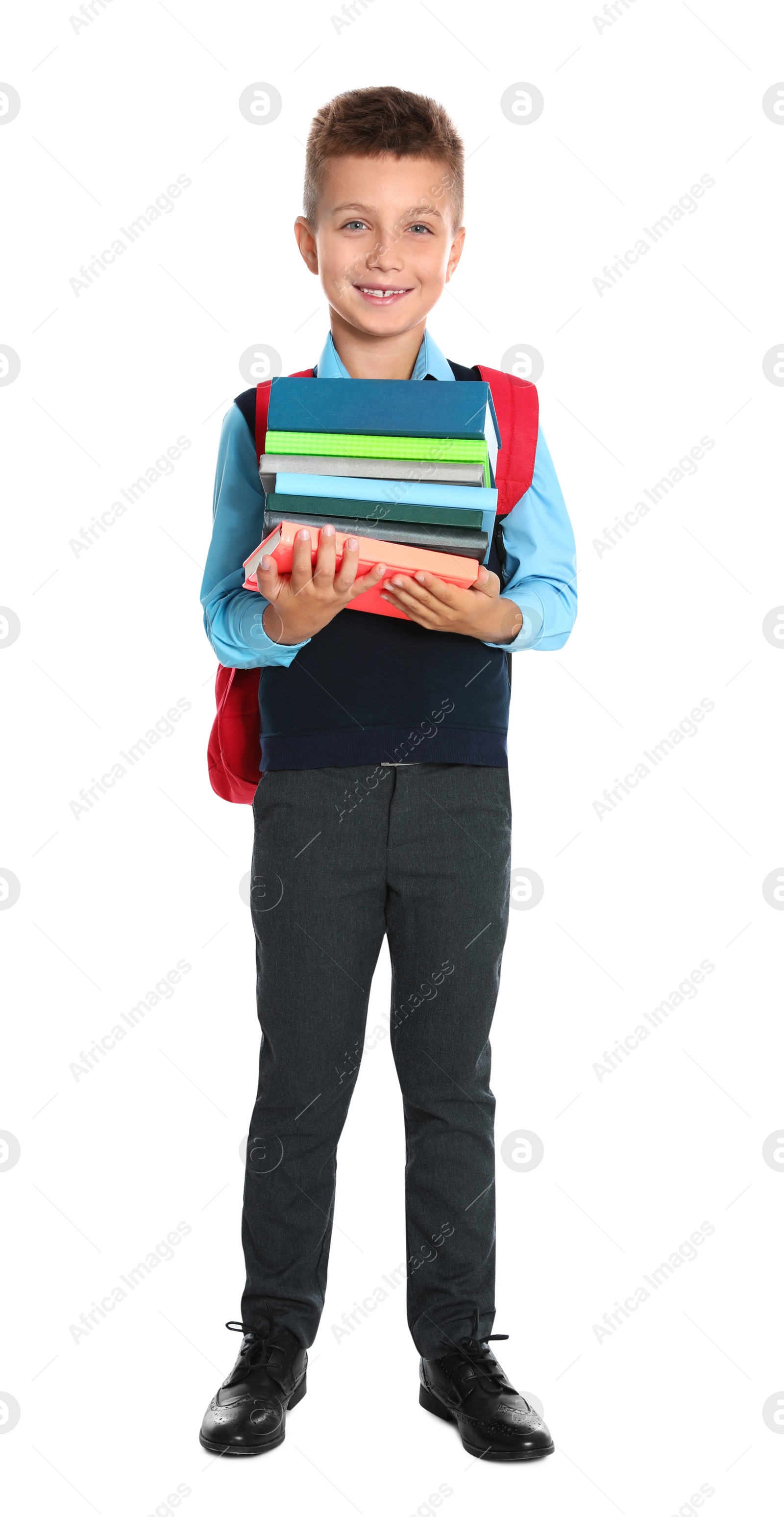 Photo of Happy boy in school uniform with stack of books on white background