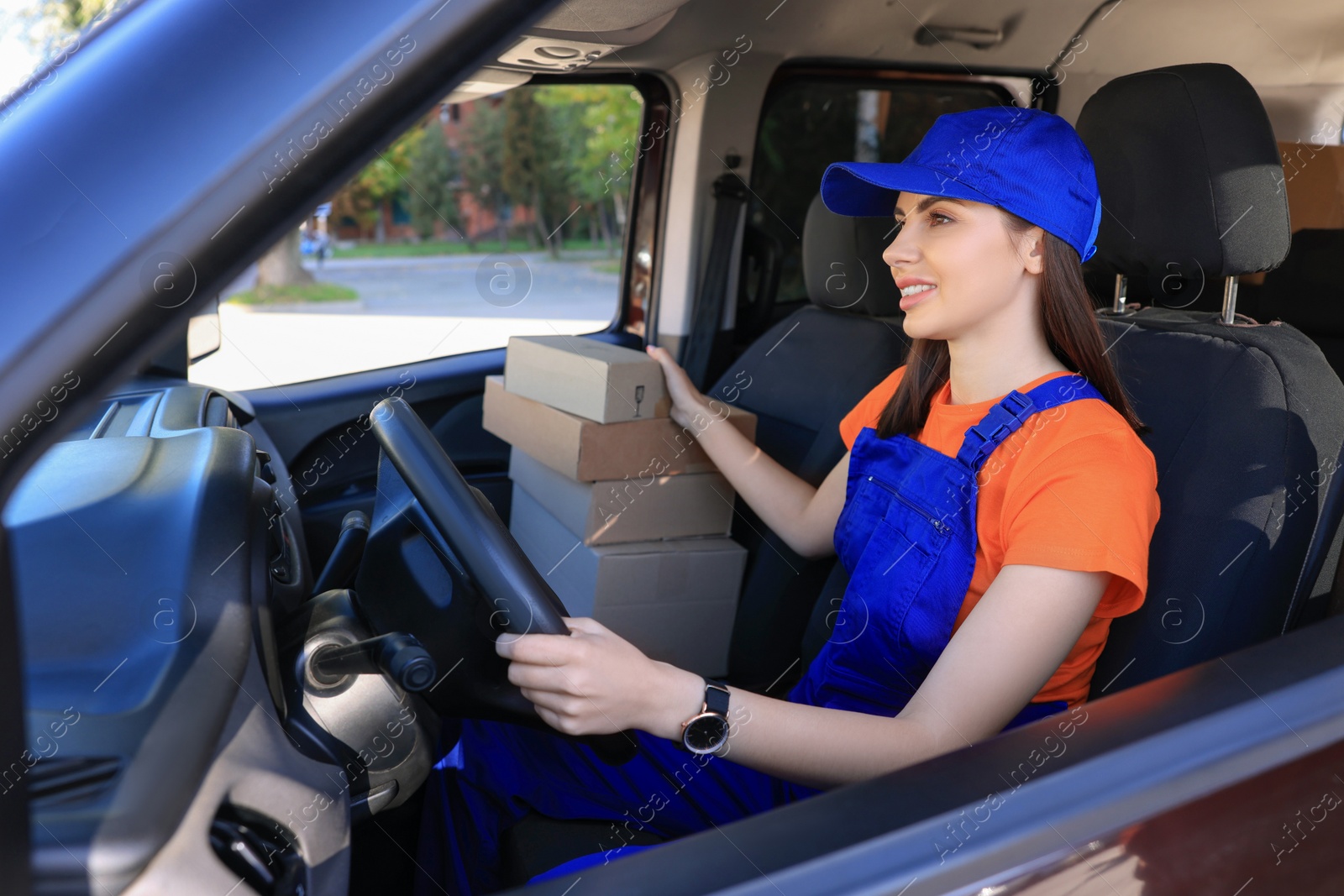 Photo of Courier checking packages in car. Delivery service