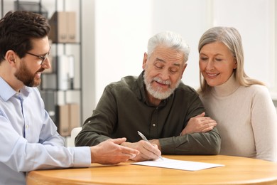 Notary consulting senior couple about Last Will and Testament in office