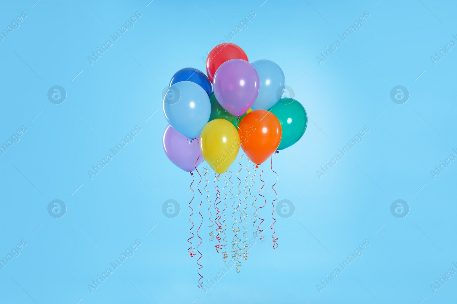 Photo of Many bright balloons floating on color background