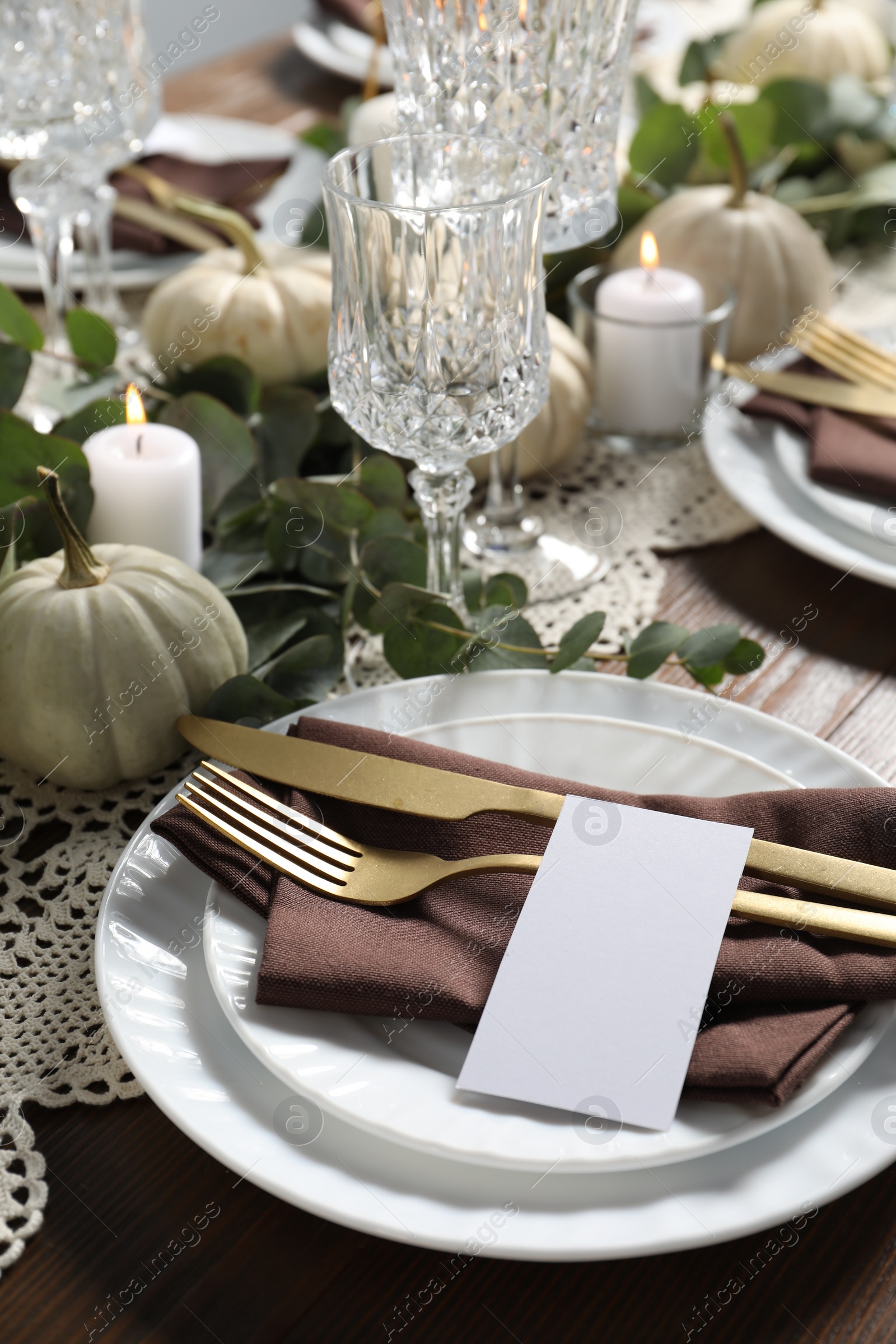 Photo of Beautiful autumn table setting. Plates, cutlery, blank card and floral decor