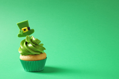 Delicious decorated cupcake on green background, space for text. St. Patrick's Day celebration