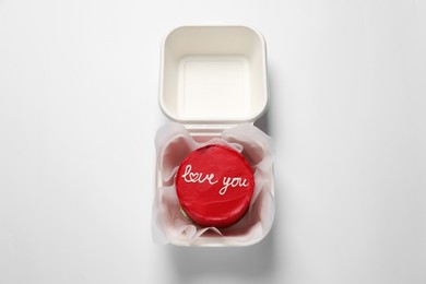 Photo of Bento cake with Love You text in takeaway box on white table, top view. St. Valentine's day surprise