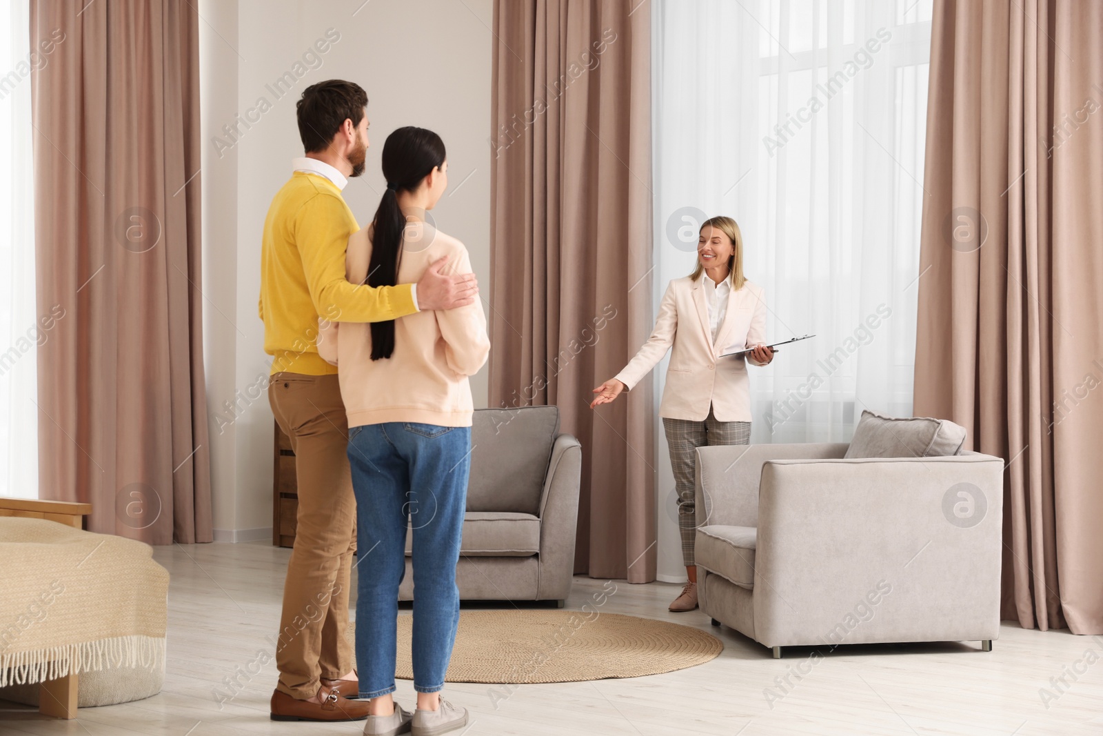 Photo of Real estate agent showing new apartment to couple