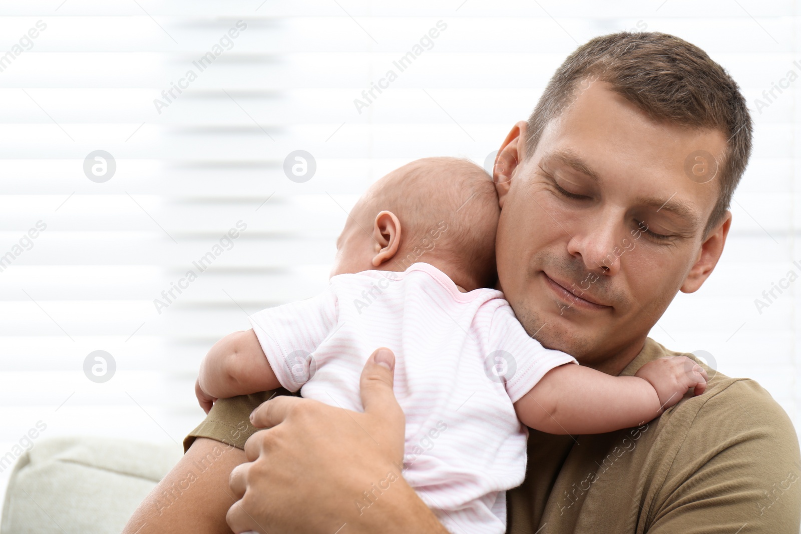 Photo of Happy father with his little baby near window