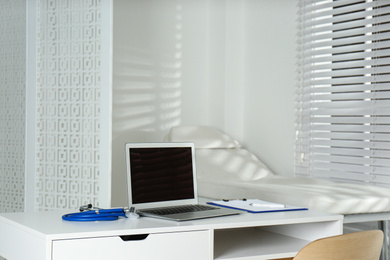 Doctor's workplace with laptop in modern clinic