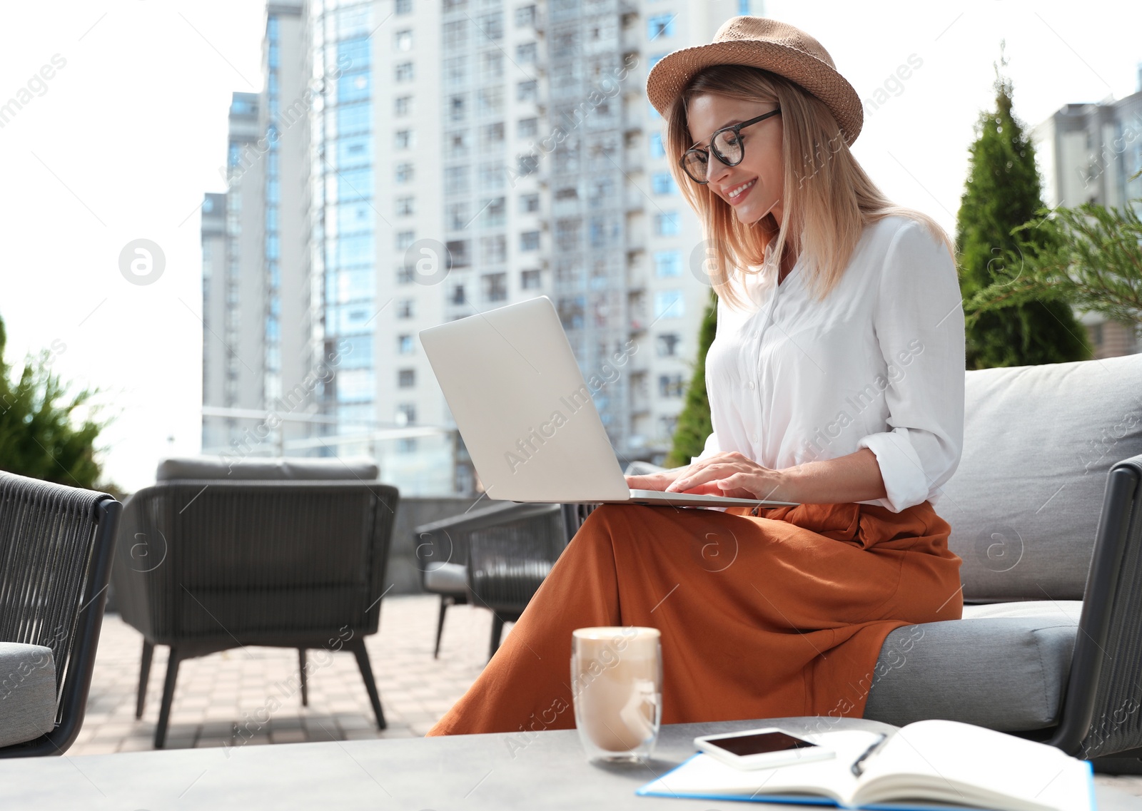 Photo of Beautiful woman using laptop at outdoor cafe