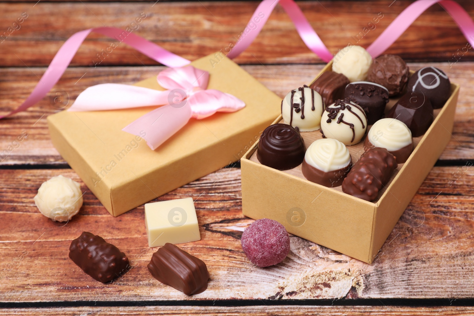 Box with tasty chocolate candies on wooden table Photo of Box with tasty chocolate candies on wooden table