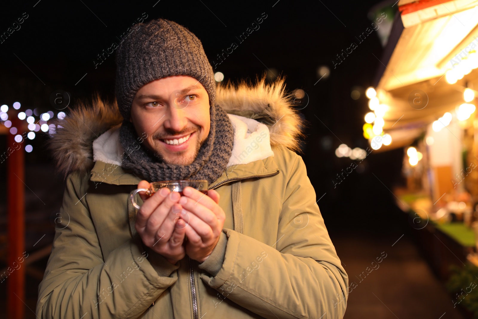 Photo of Happy man with mulled wine at winter fair