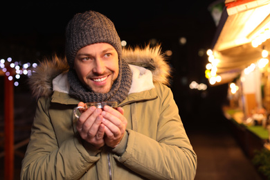 Photo of Happy man with mulled wine at winter fair