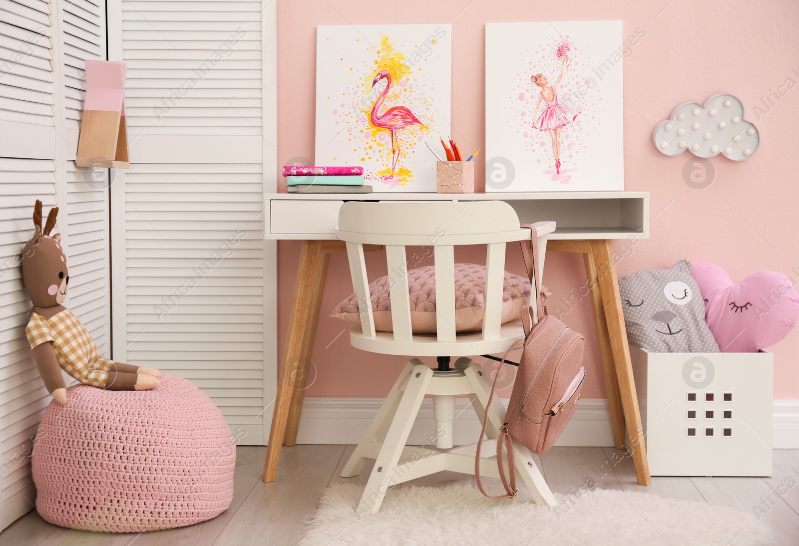 Photo of Stationery and pictures on white table in children's room. Interior design