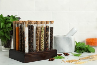 Photo of Glass tubes with different spices on kitchen counter
