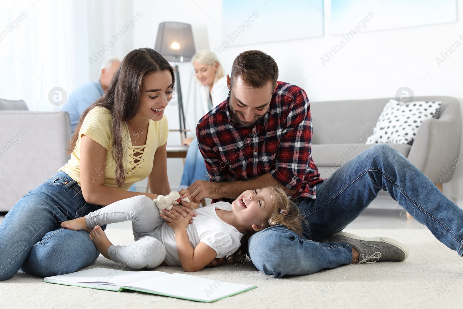 Photo of Young couple spending time with their daughter at home. Happy family