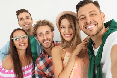 Group of happy young people taking selfie on white background