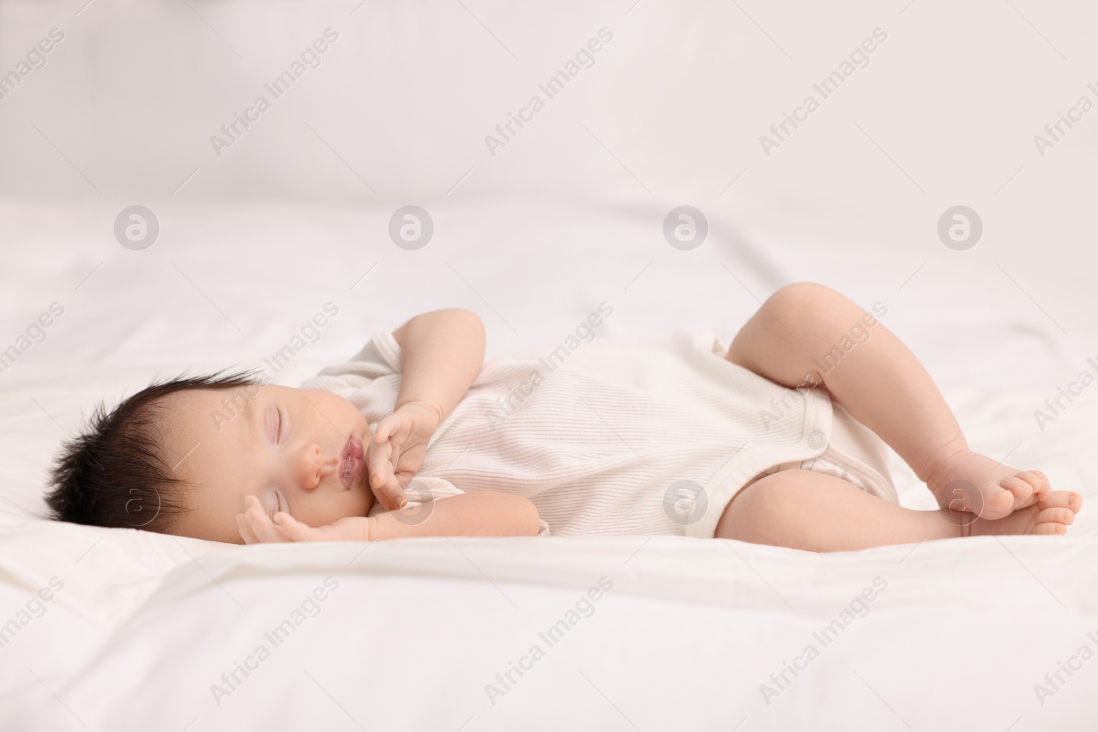 Photo of Cute newborn baby sleeping on bed at home