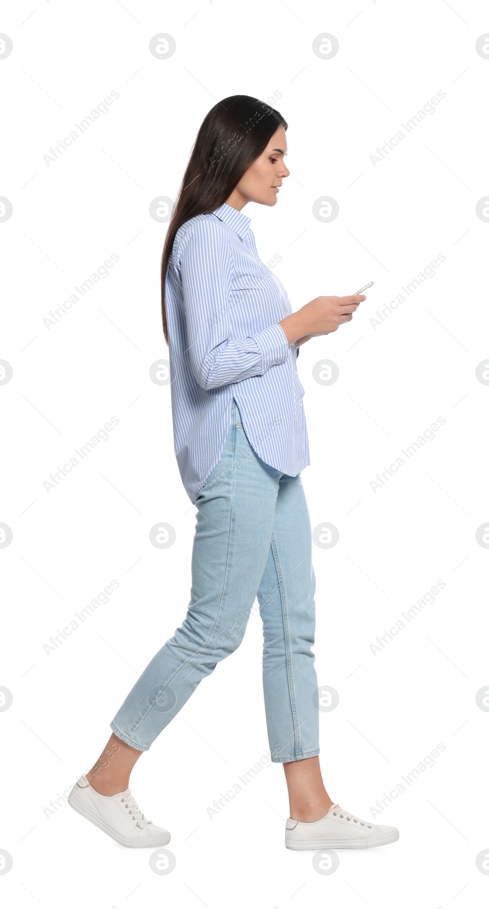Photo of Young woman with smartphone walking on white background