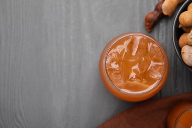 Freshly made tamarind juice on grey wooden table, flat lay. Space for text