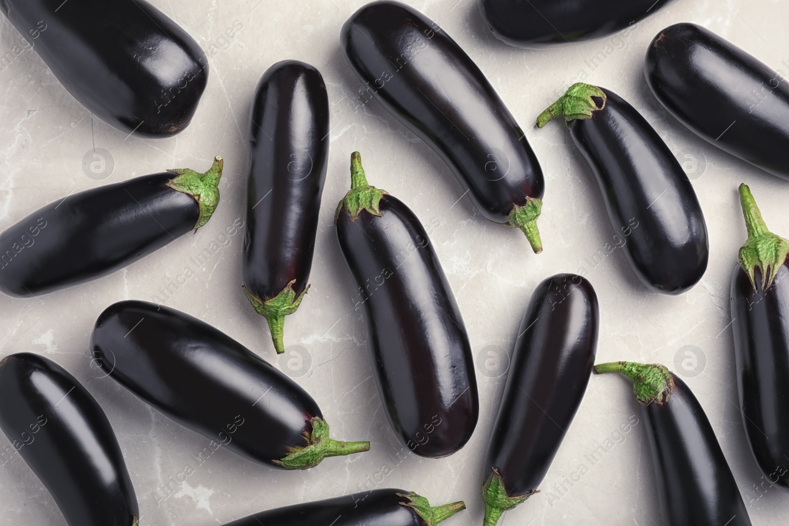 Photo of Raw ripe eggplants on light background, top view