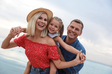 Photo of Happy family spending time together near sea on sunny summer day