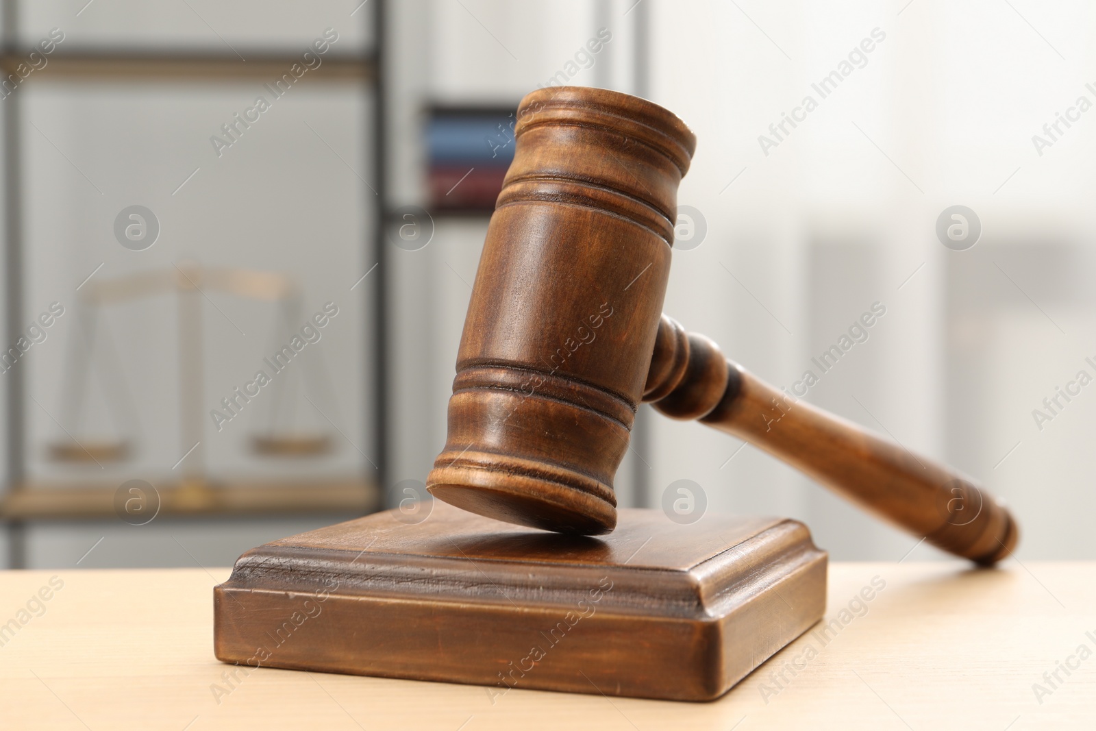 Photo of Wooden gavel and sound block on table indoors, closeup