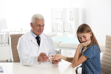 Doctor taking patient's blood sample with lancet pen in hospital. Diabetes control