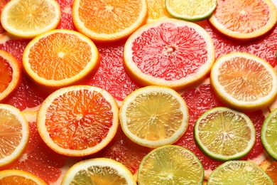 Photo of Slices of fresh citrus fruits as background