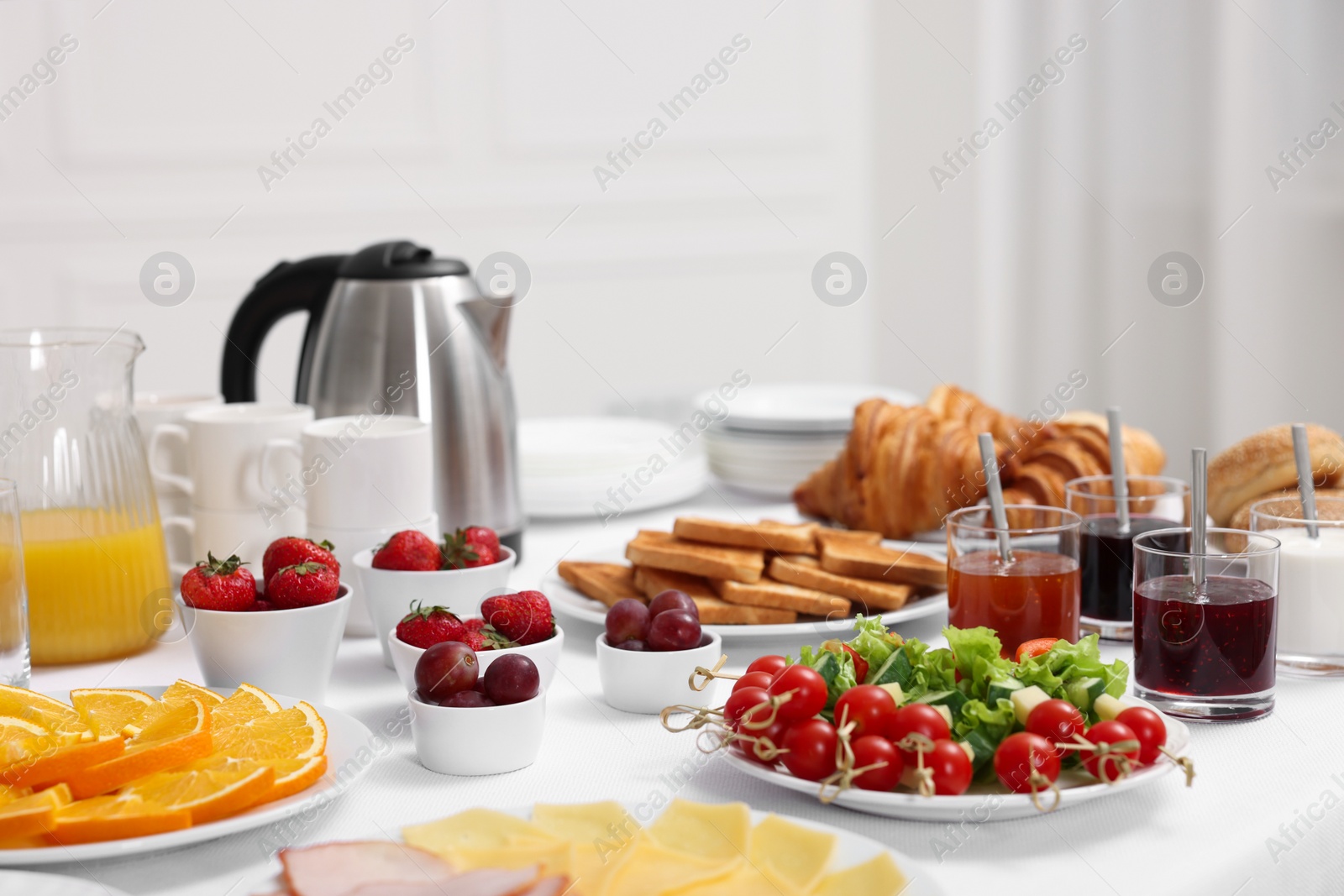 Photo of Different meals served on white table indoors. Buffet menu