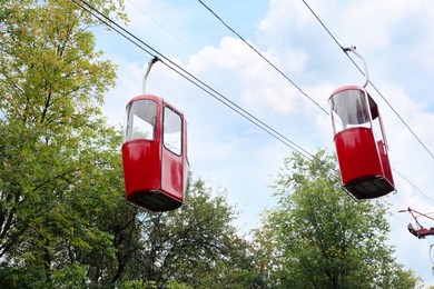 Photo of View of cableway with bright cabins in park on autumn day