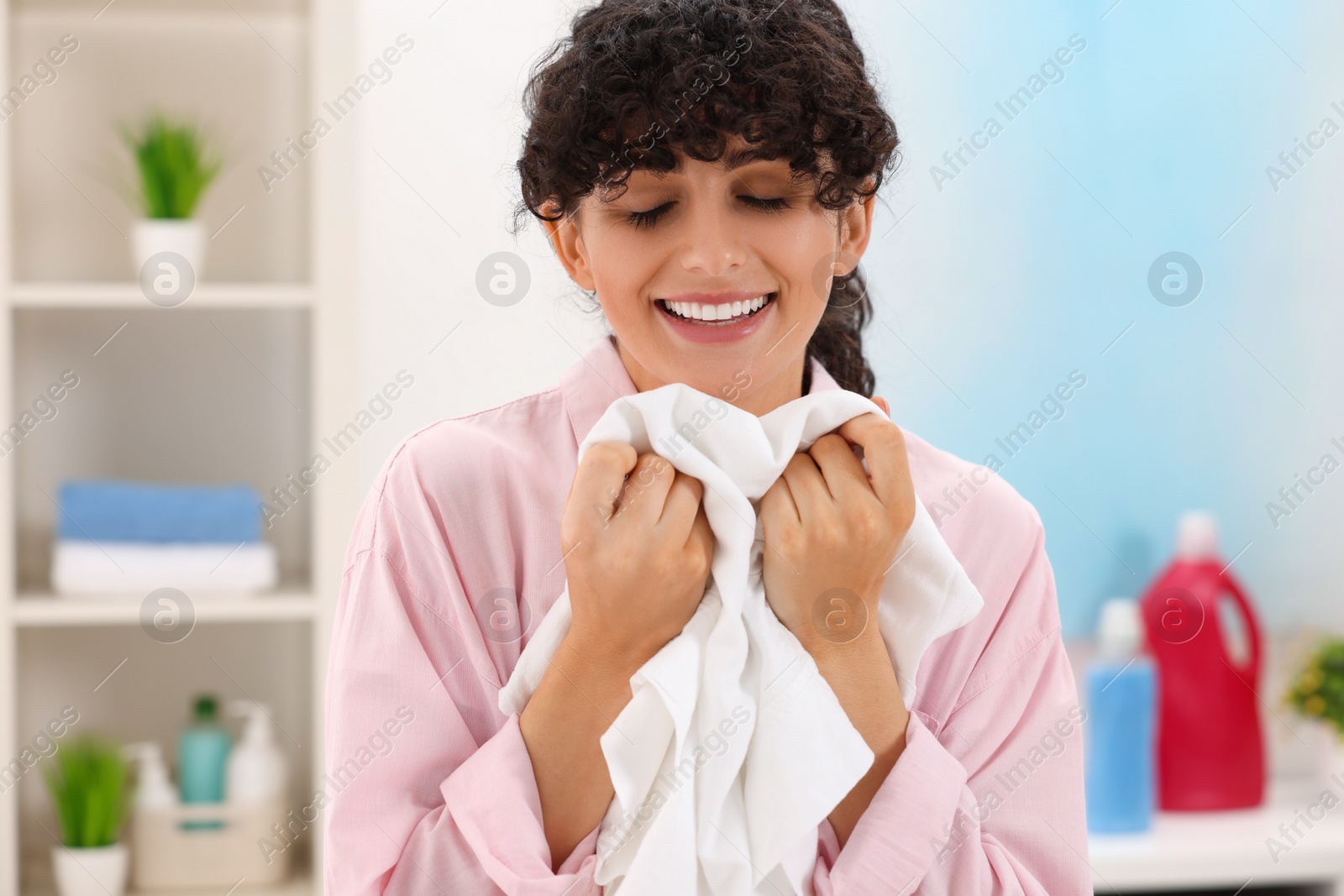 Photo of Beautiful woman with clean laundry at home