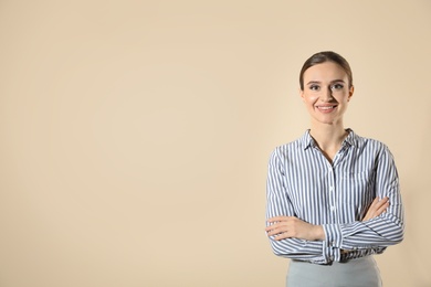 Portrait of young female teacher on beige background. Space for text