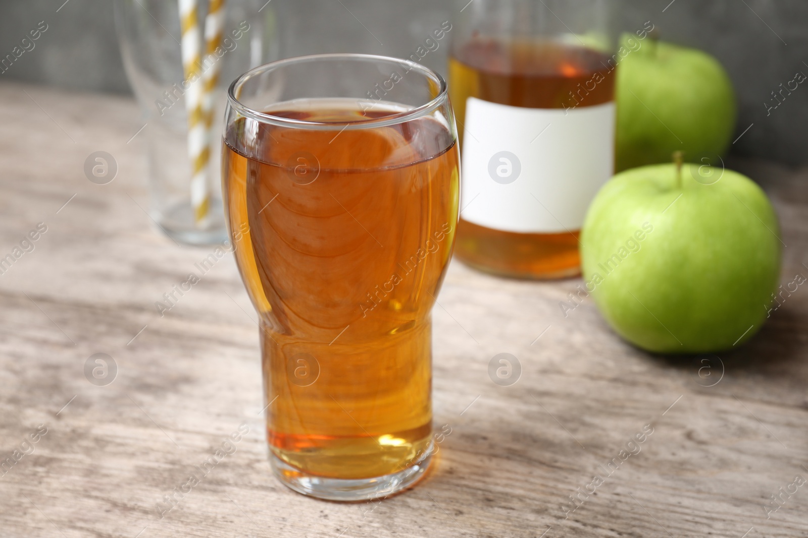 Photo of Glass of fresh apple juice on wooden table