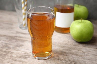 Glass of fresh apple juice on wooden table