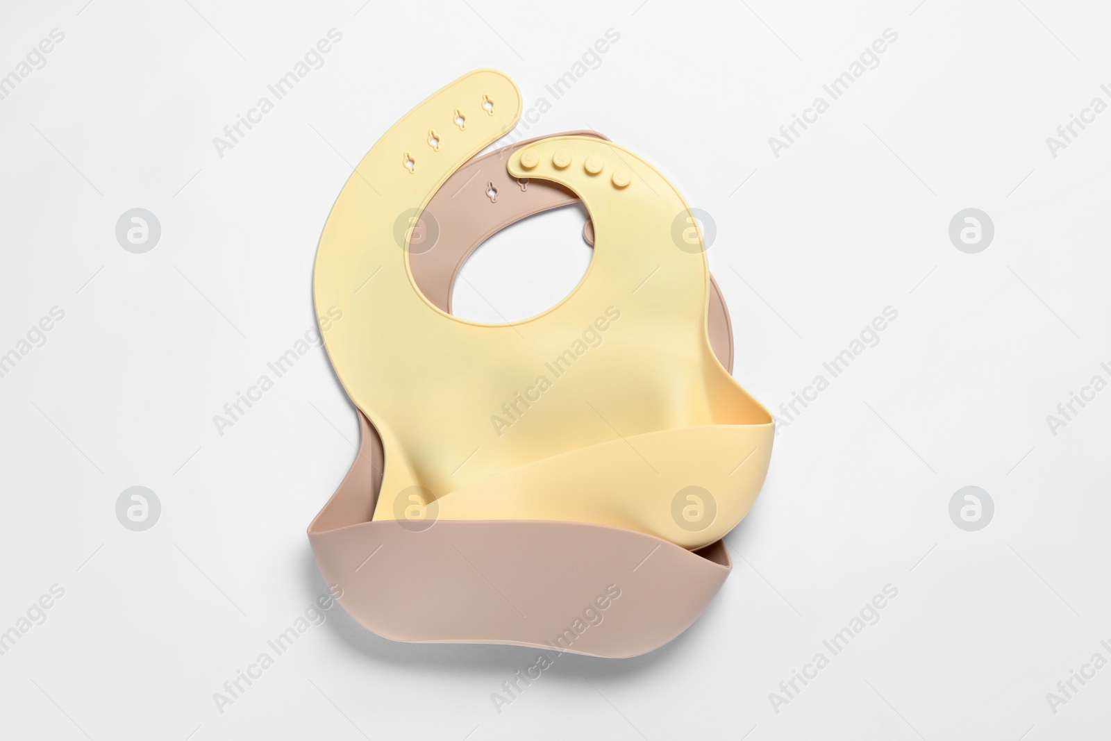 Photo of Color silicone baby bibs isolated on white, top view