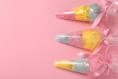 Packaged sweet cotton candies on pink background, flat lay. Space for text