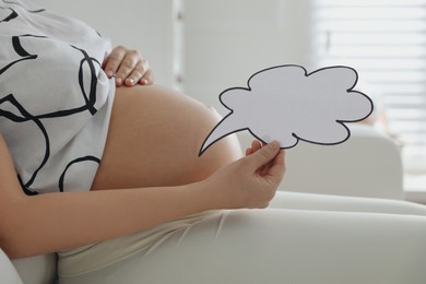 Photo of Pregnant woman with empty paper thought cloud indoors, closeup. Choosing baby name