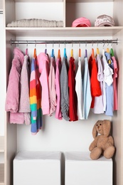 Photo of Wardrobe with stylish girl's clothes hanging on rack